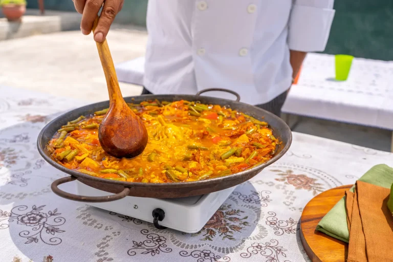 Koch bereitet Paella in Valencia zu